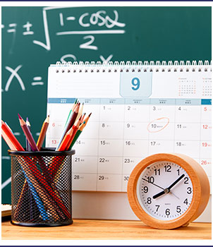 Clock and school supplies next to a calendar
