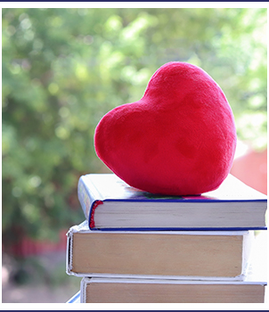 Red heart sitting on top of books